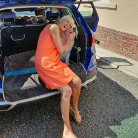 Chien et Nathalie assis dans le coffre de la voiture devant la location Villa Chantebrise